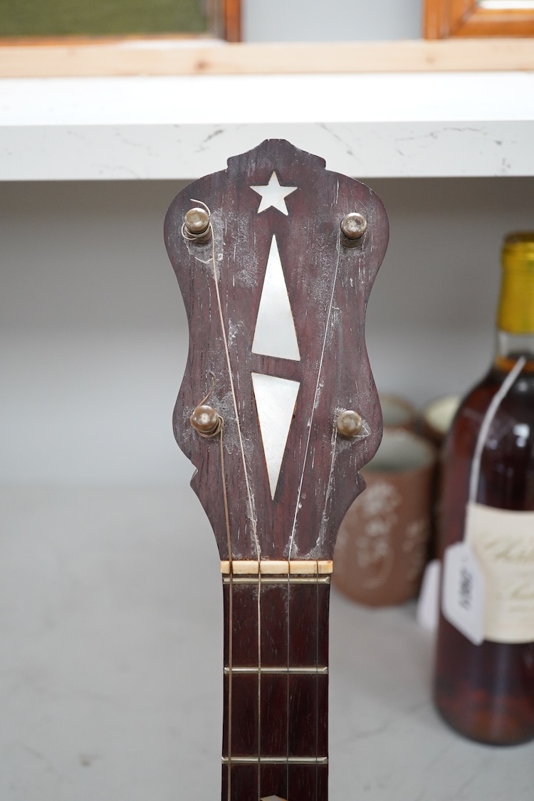 A cased Vega 4-string tenor banjo stamped M. Roccia, steel body with veneered back, the case embossed with; Ronald Quilter, 10, Cadogan Lane, London S.W.1., overall length 82cm